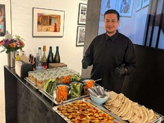 dean&david Catering | Stuttgart - Catering Station mit Gemüsesticks, Dips, Fladenbrot und Spießen, betreut von Servicepersonal für frisches Fingerfood bei Events.