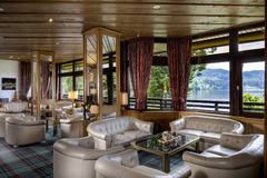 Die Lobby des Maritim Hotels Titisee bietet eine einladende Atmosphäre mit gemütlichen Sesseln. Der stilvoll gestaltete Bereich lädt zum Entspannen und Verweilen ein, umgeben von rustikalem Design und entspannender Beleuchtung.