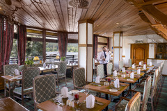 Im Restaurant 'Vier Täler' des Maritim Hotels Titisee genießen Gäste ein köstliches Dinner mit atemberaubendem Seeblick. Das elegante Ambiente und die feine Küche bieten ein unvergessliches Abendessen.