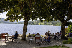 Der Biergarten des Maritim Hotels Titisee lädt mit gemütlichen Sitzplätzen im Freien und rustikalem Charme zum Entspannen ein. Gäste genießen erfrischende Getränke und Snacks in einer angenehmen Umgebung.