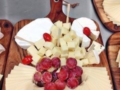 Liebevoll angerichtete Käseplatte auf Holzbrett mit Weintrauben und Weichkäse. Hochwertiges Fingerfood & Kaltspeisen-Catering von Christians Catering in Bernburg & Region.
