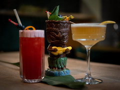Dreier-Set aus kreativen Cocktails: fruchtiger Longdrink, exotischer Tiki-Drink und eleganter Sour-Cocktail – kunstvoll angerichtet mit Dekoration.