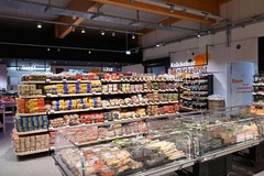 Innenansicht des tegut... Supermarktes mit verschiedenen Brotsorten im Vordergrund und Feinkost-Bedientheken im Hintergrund.