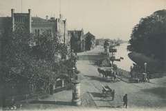 Das historische Foto zeigt die Staulinie in Oldenburg, eine malerische Straße entlang des Hafens mit Blick auf das Stadtbild und den Wasserlauf. Dieses beeindruckende Bild veranschaulicht die Geschichte und den Charme der Stadt. Die Alte Stadtkasse, ein z