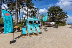 FirstLoveCoffee GmbH - Kaffee Catering Berlin - Türkiser Kaffeeanhänger mit Liegestühlen und Beach-Atmosphäre für Outdoor Catering, Bio-Kaffee, frische Waffeln und mobilen Barista-Service.