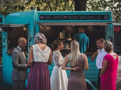 FirstLoveCoffee GmbH - Kaffee Catering Berlin - Kaffeeanhänger bei einer Hochzeit mit Brautpaar und Gästen, Bio-Kaffee, Tee und frische Waffeln als besonderes Catering für Hochzeitsfeiern.