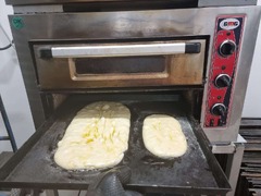 San Leone Mobile Pizza | Foodtruck & Catering Solingen - Zwei handgeformte Brotteiglinge auf einem Backblech vor dem Backen. Ein Einblick in die handwerkliche Herstellung von italienischem Brot und Ciabatta mit luftigem Teig.