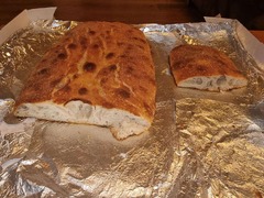 San Leone Mobile Pizza | Foodtruck & Catering Solingen - Frisch gebackenes italienisches Ciabatta-Brot mit goldbrauner Kruste und angeschnittener, luftiger Krume. Handwerklich hergestelltes Brot als Beilage zu Antipasti und italienischen Speisen.