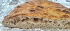 San Leone Mobile Pizza | Foodtruck & Catering Solingen - Nahaufnahme eines aufgeschnittenen Ciabatta-Brotes mit großporiger Teigstruktur und knuspriger Oberfläche. Die sichtbaren Luftkammern zeigen die lockere Krume des italienischen Brotes.