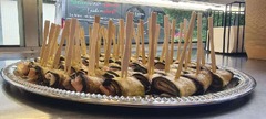 San Leone Mobile Pizza | Foodtruck & Catering Solingen - Gefüllte und aufgerollte Auberginenscheiben mit kleinen Holzspießen auf einer silbernen Servierplatte. Italienische Gemüse-Antipasti als Fingerfood für Catering und Veranstaltungen.