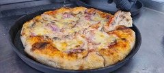 San Leone Mobile Pizza | Foodtruck & Catering Solingen - Frisch gebackene Pizza mit geschmolzenem Käse, Champignons und roten Zwiebeln. Der aufgeschnittene Pizzarand zeigt eine besonders luftige Teigstruktur mit großen Poren.