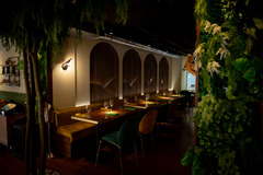 Stimmungsvoll beleuchteter Restaurantbereich mit eleganten Sitznischen, warmem Licht und üppiger grüner Wandgestaltung – ideal für ein stilvolles Dinner.