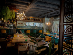 Einladender Restaurantbereich mit rustikaler Decke, grünem Interior, stilvoll gedeckten Tischen und atmosphärischer Beleuchtung – modernes Ambiente mit Naturflair.