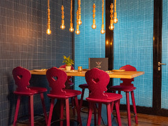 Sitzecke mit Holztisch, pinken Stühlen und warmem Licht im Restaurant Das Blümchen Friedrichshafen – modernes Schwarzwald-Design mit Wohlfühlatmosphäre.
