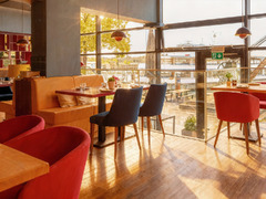 Heller Gastraum mit großen Fenstern und Blick auf den Bodensee im Restaurant Das Blümchen Friedrichshafen – sonnige Atmosphäre und modernes Design.
