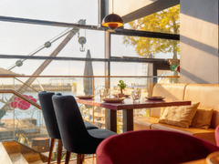 Blick aus dem Restaurant Das Blümchen Friedrichshafen auf den Bodensee – sonnendurchfluteter Gastraum mit Fensterfront und moderner Einrichtung.