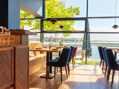 Heller Gastraum mit großen Fenstern und Blick auf den Bodensee im Restaurant Das Blümchen Friedrichshafen – modernes Ambiente mit Seelandschaft.