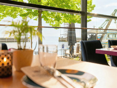 Tischgedeck am Fenster mit Blick auf Seeufer und Bäume im Restaurant Das Blümchen Friedrichshafen – harmonische Verbindung von Natur und Kulinarik.