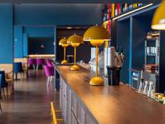 Moderner Barbereich mit gelben Designlampen im Restaurant Das Blümchen Friedrichshafen – stilvolles Interieur und gemütliche Atmosphäre am Bodensee.