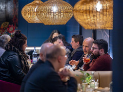 Gäste genießen Tapas und Drinks im Restaurant Das Blümchen Friedrichshafen unter warmem Licht.