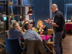 Gruppe von Gästen im Restaurant Das Blümchen im Gespräch mit Gastgeber Sascha Halweg.