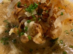 Geschlossene Gesellschaft Nahaufnahme einer edlen Suppe mit knusprigem Topping und frischen Kräutern – Fine Dining bei Geschlossene Gesellschaft von Wulf Mey.