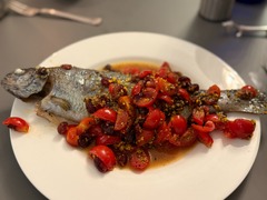 Geschlossene Gesellschaft Ganzer Fisch mit Tomaten und Kräutern, kreativ zubereitet und präsentiert bei Geschlossene Gesellschaft Hamburg.