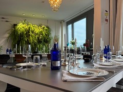 Geschlossene Gesellschaft präsentiert einen edel gedeckten Esstisch mit stilvoller Tischdekoration, Gläsern und modernem Ambiente unter einem goldenen Kronleuchter in Hamburg.