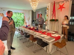 Geschlossene Gesellschaft zeigt eine festlich gedeckte Tafel mit Kerzen, roter Tischdekoration und Gästen bei einem exklusiven Abendessen in Hamburg.