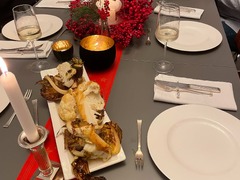 Geschlossene Gesellschaft schafft ein festliches Ambiente mit roten Dekorationen, Kerzen und Vorspeisen für ein unvergessliches Dinner in Hamburg.