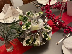 Geschlossene Gesellschaft präsentiert Austern mit frischen Kräutern auf Etageren, Teil des Fine Dining Menüs in Hamburg.