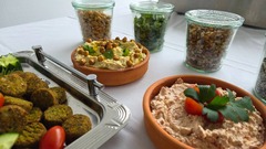dean&david Catering | Karlsruhe - Frische Falafelplatte mit Hummus, cremigem Dip, Nüssen, Kräutern und Aufstrichen als vielseitige Fingerfood Auswahl für Event Catering.