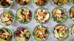 dean&david Catering | Pforzheim - Frische Salate im Glas mit Falafel, Hummus, Minze, Granatapfel und knackigem Gemüse neben Chicken Bowls mit Limette für vielseitiges Event Catering.
