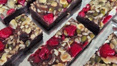 dean&david Catering | Pforzheim - Schokoladen-Brownies mit Himbeeren, Mandeln, Kürbiskernen und Sonnenblumenkernen auf Servierplatte als süßes Dessert für Buffet und Catering.