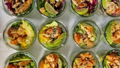 dean&david Catering | Pforzheim - Bunte Bowl-Auswahl im Glas mit gegrilltem Hähnchen, Limette, Gurke, Rotkohl sowie Lachs, Avocado und Mango für frisches Business Catering.