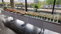 dean&david Catering | Pforzheim - Langes Catering Buffet mit Wraps, Sandwiches und vielen Bowls im Glas vor großer Fensterfront für Empfang, Tagung oder Business Lunch.