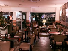 Die Feinschmecker Catering & Partyservice Hamburg - Gemütlicher Innenraum eines modernen Bistros und Cafés in Hamburg mit einladenden Sitzecken, Teppichen, stilvoller Beleuchtung und weihnachtlicher Dekoration für exklusive Events.