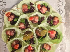 Die Feinschmecker Catering & Partyservice Hamburg - Herzhafte Fingerfood-Häppchen im Speckmantel, einzeln angerichtet mit Salat, Petersilie und Tomate. Kleine Snacks für Buffet, Empfang, Feier und Catering in Hamburg.