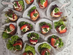 Die Feinschmecker Catering & Partyservice Hamburg - Dekorativ angerichtetes Fingerfood mit Speckmantel, Salat, Kräutern und frischen Erdbeeren. Kleine herzhafte Häppchen für Sektempfang, Partybuffet und Veranstaltungen.