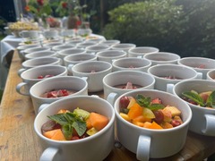 Die Feinschmecker Catering & Partyservice Hamburg - Portionsweise vorbereitete Obstbecher mit Melone, Kiwi, Trauben, Granatapfel und frischer Minze. Frisches Obst als Dessert oder leichte Ergänzung für Catering-Buffets.
