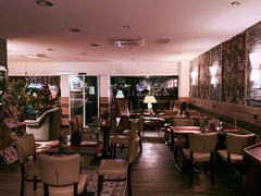 Die Feinschmecker Catering & Partyservice Hamburg - Innenbereich mit mehreren gedeckten Tischen, Stühlen und gemütlichen Sesseln. Geräumiger Restaurant- und Cafébereich für Gäste, Essen und kleinere Veranstaltungen.
