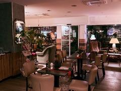 Die Feinschmecker Catering & Partyservice Hamburg - Blick durch den gemütlich eingerichteten Gastraum mit Tischen, Stühlen, Sesseln und dekorativem Innenbereich. Sitzmöglichkeiten für Café- und Restaurantbesucher.