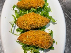 Knusprige panierte Tapas auf Rucola. "Croquetas".